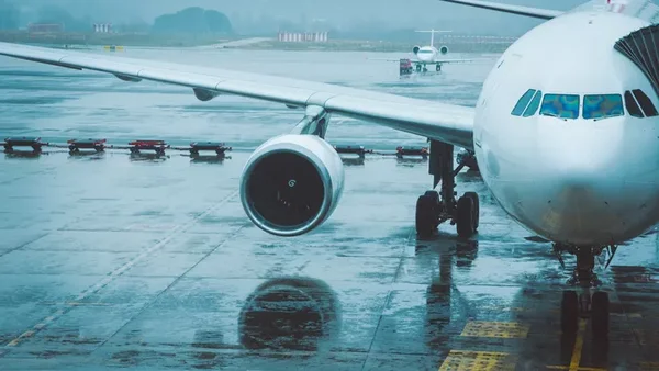 Un avion commercial sur un tarmac détrempé par la pluie.