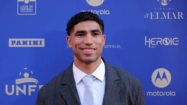 Achraf Hakimi en costume lors d'un événement officiel.