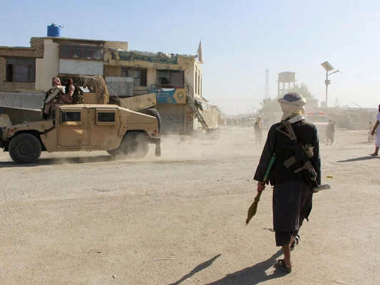 Un combattant afghan armé d'un lance-roquettes sur une route après les frappes pakistanaises.