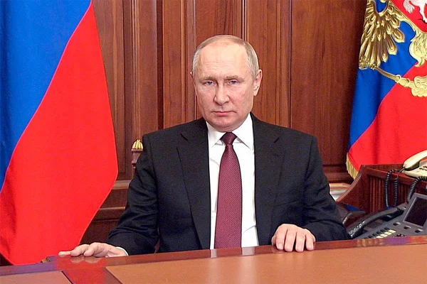 Vladimir Poutine derrière son bureau officiel, entouré des symboles de l'État russe.