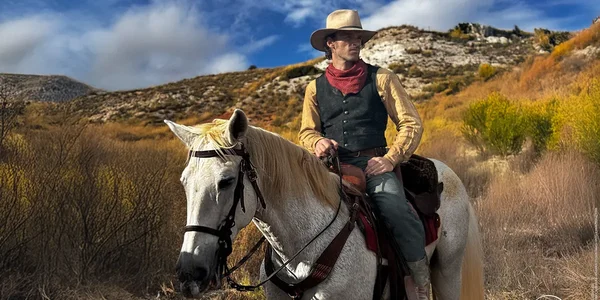 Un cow-boy solitaire à cheval dans un paysage de l'Ouest américain, évocateur de l'atmosphère de Lucky Luke.