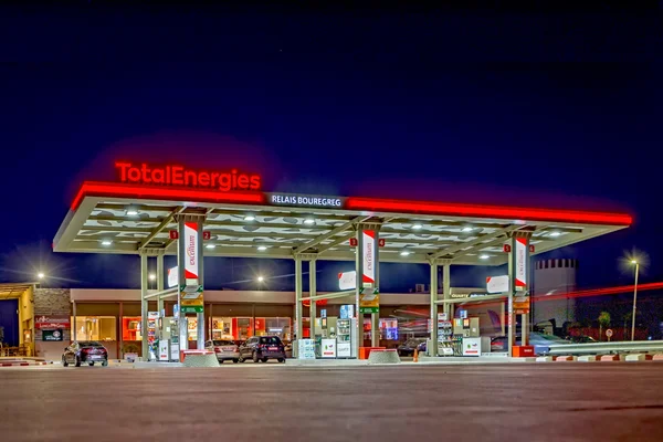 Station-service TotalEnergies de nuit, illustrant l'activité de vente de carburants aux clients.