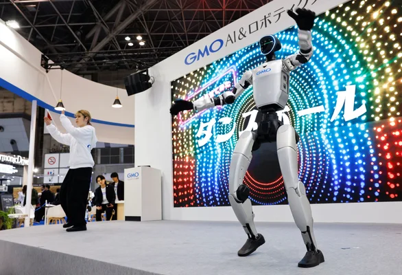 Un robot humanoïde exécute une danse sur scène lors d'un événement technologique au Japon.