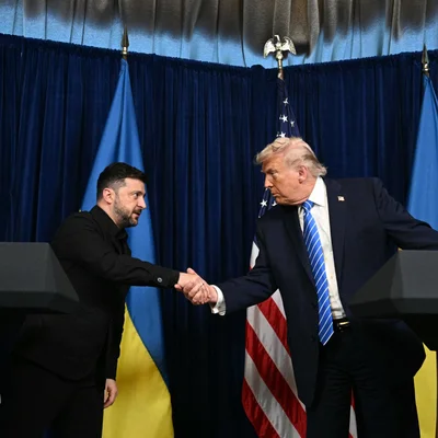 Poignée de main entre Volodymyr Zelensky et Donald Trump devant les drapeaux des deux nations.