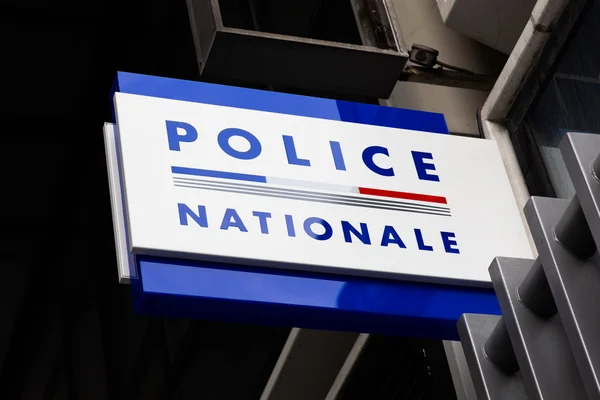 Panneau 'Police Nationale' illuminé sur un bâtiment.