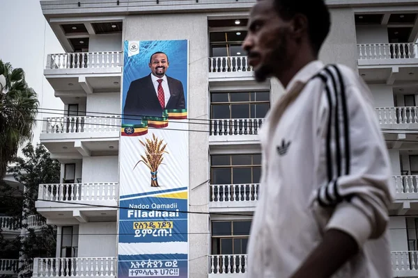 Passant devant une affiche de campagne d'Abiy Ahmed.