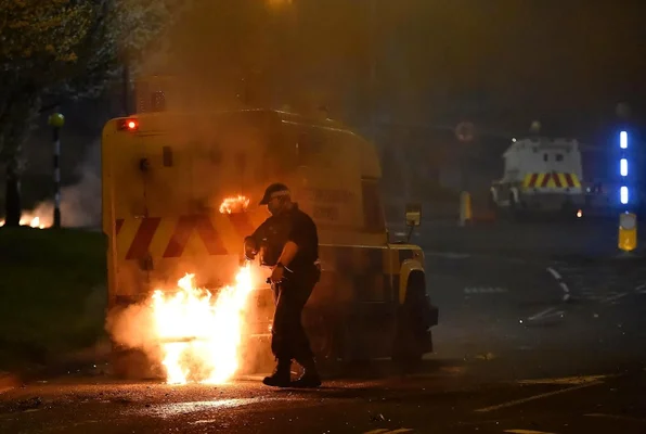 Véhicule blindé de police en feu lors d'une manifestation à Belfast.