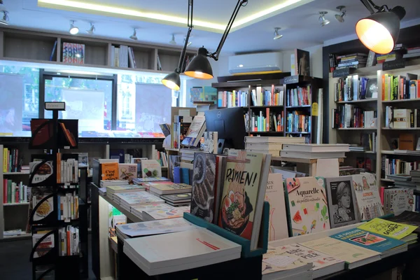 Intérieur d'une librairie indépendante, avec ses rayonnages et sa table de présentation.