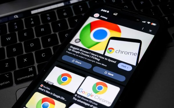 Smartphone affichant Google Chrome posé sur un clavier d'ordinateur portable.
