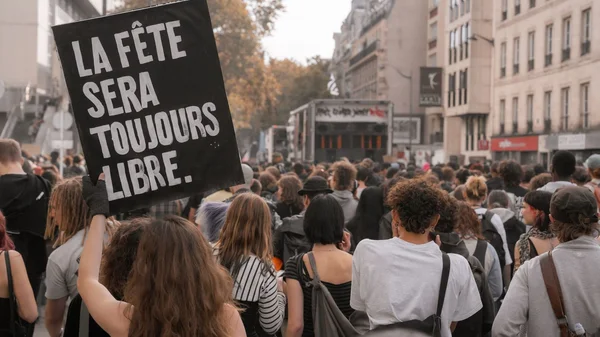 Manifestation à Paris : des milliers de teufeurs défilent, une pancarte 'LA FÊTE SERA TOUJOURS LIBRE' brandie.