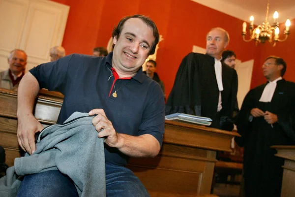 Vincent Reynouard lors de son procès, souriant dans une salle d'audience.