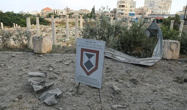 Panneau du site archéologique de Tyr, entouré de ruines antiques et de la ville moderne.