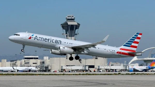 Un Airbus A321 d'American Airlines décolle devant la tour de contrôle d'un aéroport.