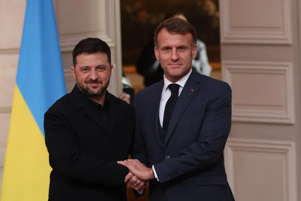 Volodymyr Zelensky et Emmanuel Macron échangeant une poignée de main lors du sommet du G7.