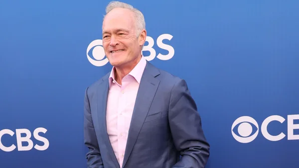 Scott Pelley devant le logo de CBS News.