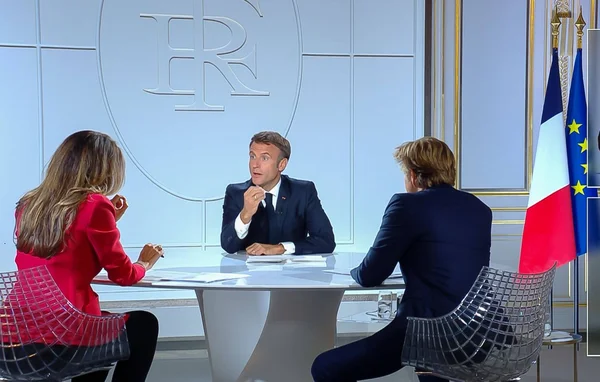 Emmanuel Macron en pleine discussion avec des journalistes lors d'une interview télévisée.
