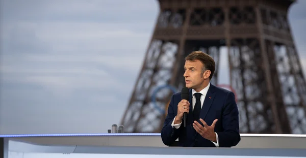 Emmanuel Macron lors de son interview, avec la tour Eiffel et les anneaux olympiques en toile de fond.