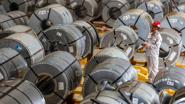Stock de bobines d’aluminium dans un entrepôt, illustrant la pression sur les matières premières.