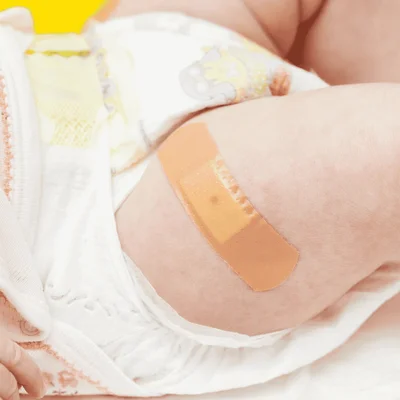 Pansement sur la cuisse d'un bébé après une injection de vitamine K.