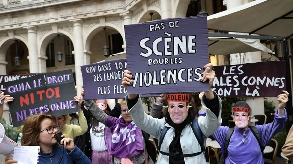 Deux manifestantes masquées avec des bandeaux « VIOLEUR » lors de l'action féministe.