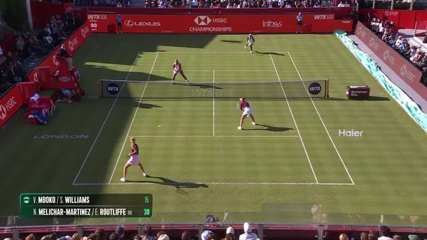 Action lors du double féminin au Queen's, avec Serena Williams en pleine rencontre.
