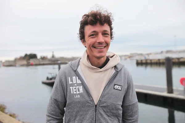 Corentin de Chatelperron, figure de la low-tech, photographié devant un port.