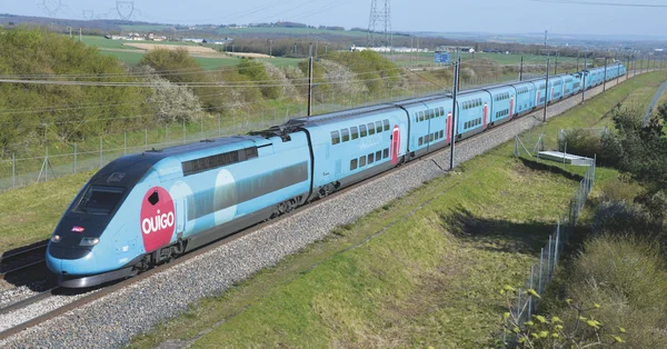 Un TGV Ouigo bleu traversant la campagne française.