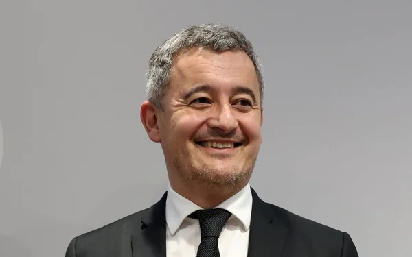 Gérald Darmanin souriant lors d'une interview.
