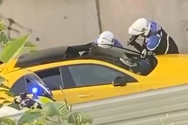 Interpellation de Nahel à Nanterre : deux policiers au bord de la voiture jaune.