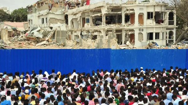 Des habitants rassemblés devant les ruines d'un immeuble détruit à Mogadiscio.