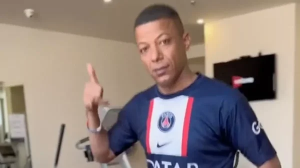 Le sosie égyptien de Kylian Mbappé en maillot de l'équipe de France avec une réplique de la Coupe du Monde.