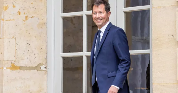 François-Xavier Bellamy souriant devant une fenêtre en pierre.