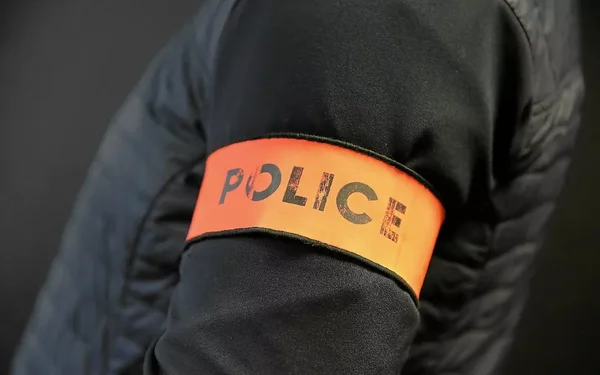 Brassard 'POLICE' porté par un agent lors de l'opération.