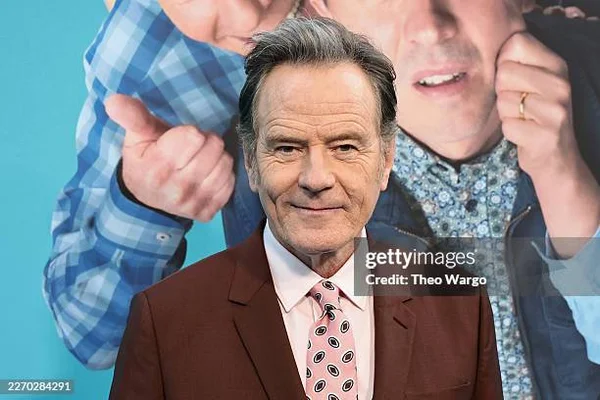 Bryan Cranston devant une affiche promotionnelle.