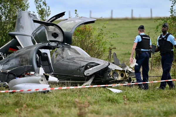 Policiers près de l'épave d'un avion militaire écrasé à Seichamps, ruban de sécurité en place.
