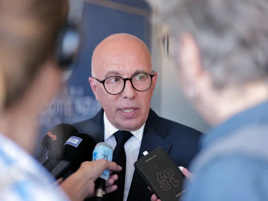 Éric Ciotti s'adressant aux médias, entouré de micros.