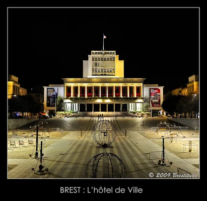 La mairie de Brest illuminée de nuit, avec la place agrémentée de sculptures en fil de fer.