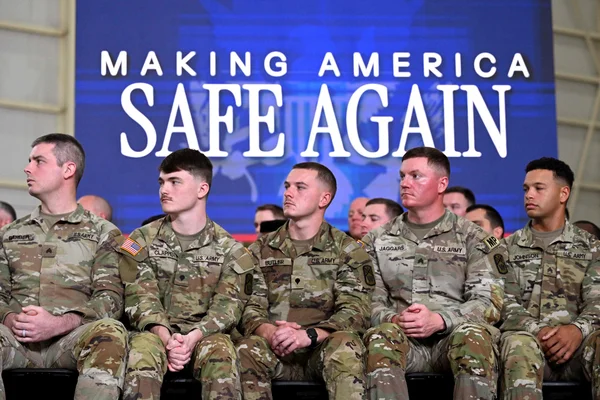 Soldats américains devant une bannière « MAKING AMERICA SAFE AGAIN ».