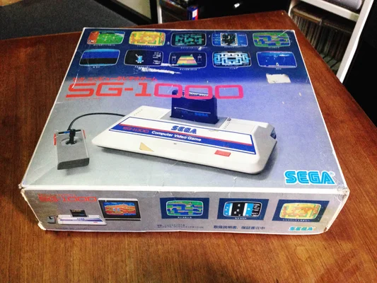 Console SEGA SG-1000 japonaise de première version, boîte d'origine sur table en bois.