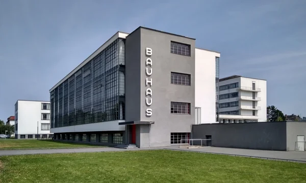 Le bâtiment du Bauhaus à Dessau, exemple emblématique de l'architecture moderniste, sous un ciel bleu.