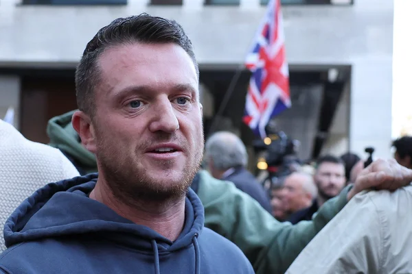 Tommy Robinson lors d'un rassemblement public, entouré de partisans.