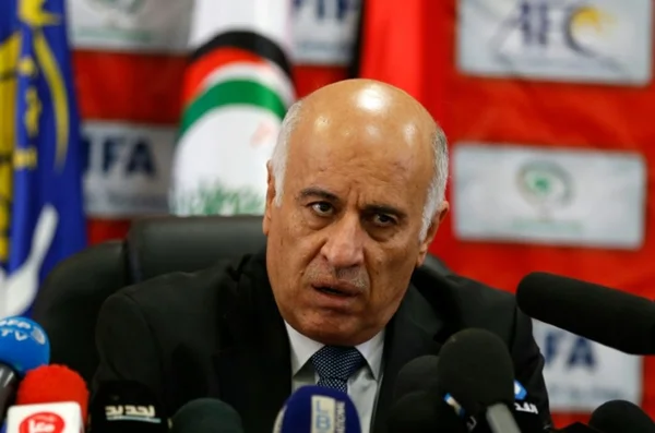 Jibril Rajoub lors d'une conférence de presse, micros et drapeaux en arrière-plan.