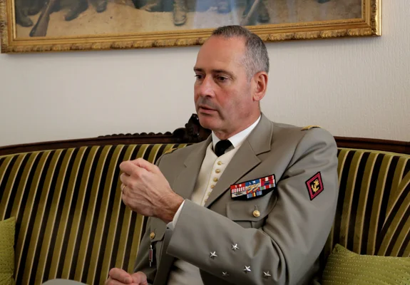 Le général Pierre Schill lors d'une interview, assis sur un canapé rayé.