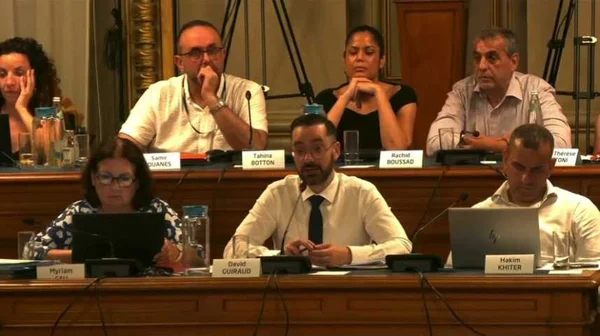 David Guiraud (au centre) participe à une réunion officielle entouré d'autres personnes.