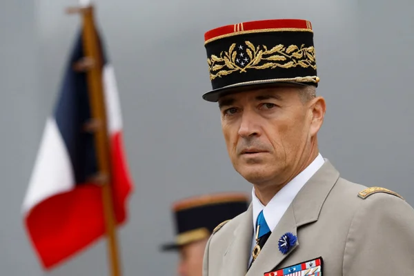 Le général Thierry Burkhard, chef d'état-major des armées, devant le drapeau français.