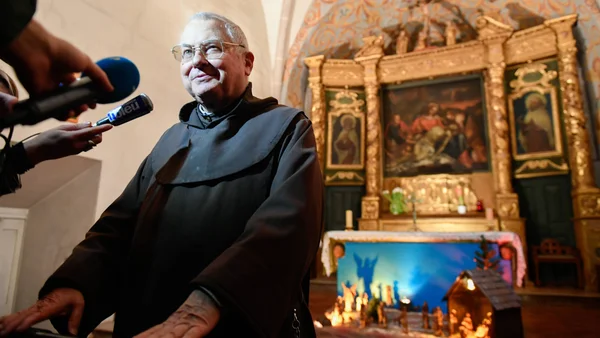 Un religieux interrogé par des journalistes dans une église.