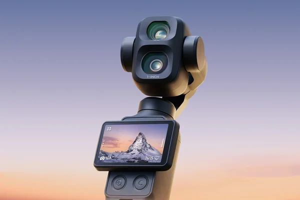 Gros plan sur la DJI Osmo Pocket 3 montrant son double objectif '1-INCH' et un paysage montagneux à l'écran.