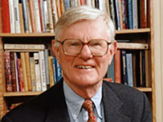 Gordon Wood assis à une table, souriant, lors d'un événement.