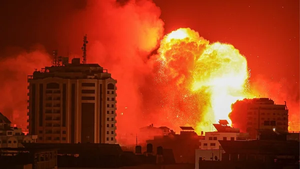 Explosion massive lors d'une frappe aérienne israélienne à Gaza, illuminant le ciel nocturne.