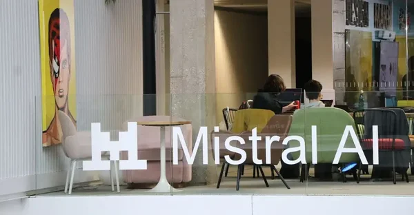 Bureau Mistral AI avec façade vitrée, branding blanc et ambiance de travail collaborative.